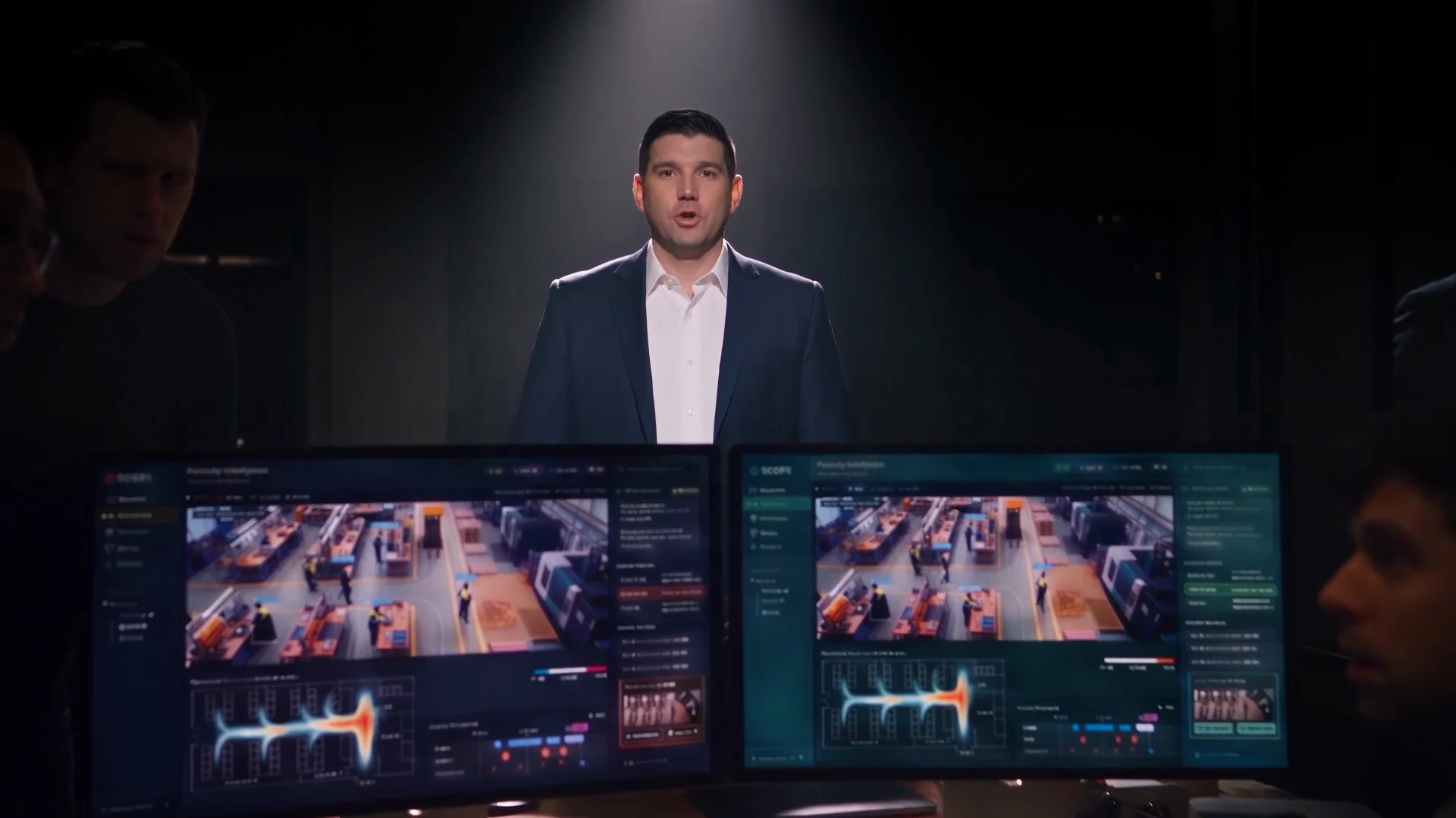 Andrew Rapacke, as his AI avatar, speaks to camera under a spotlight in The Clone.